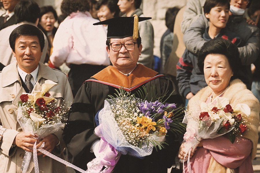 구본무 회장(왼쪽)이 1986년 구자경 회장(가운데)의 고려대학교 명예경제학박사 학위 수여식장에서 기념사진 촬영을 하고 있다. 오른쪽은 구본무 회장의 어머니인 하정임 여사